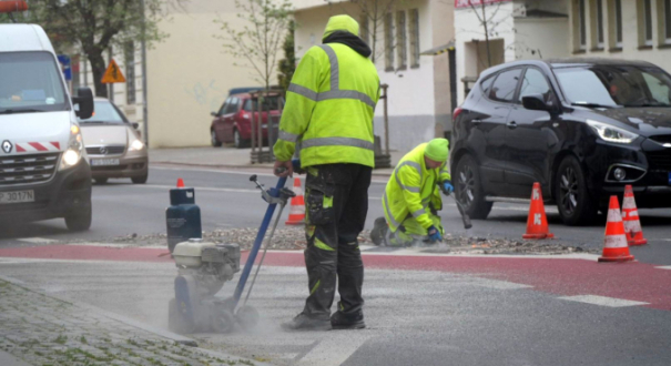 Usuwanie oznakowania palnikiem na ul. Dąbrowskiego w Gorzowie. Likwidacja martwych pól przy straży pożarnej JRG2 przed malowaniem pasów.